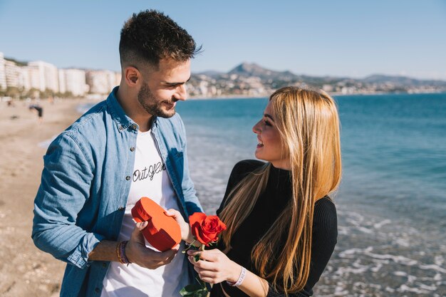 Verliefd paar met giften op strand