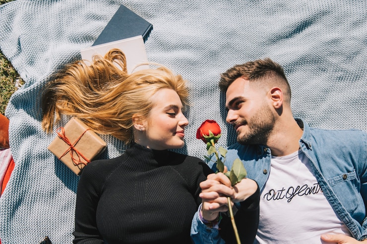 Gratis Foto verliefd paar met roos op plaid