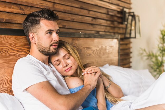 Verliefde paar bedrijf hand op bed