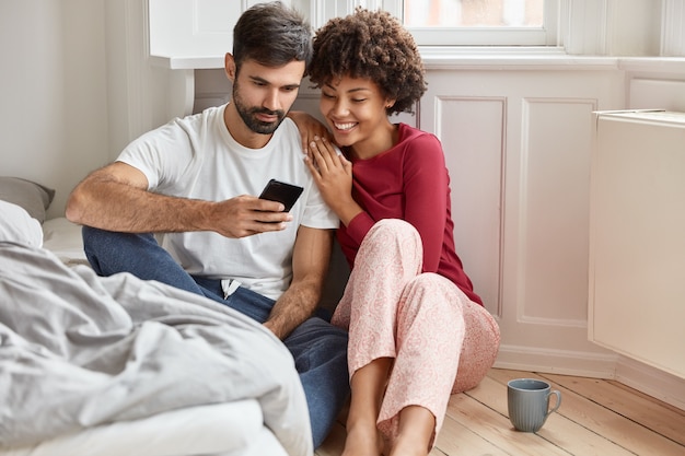 Verliefde paar kijken naar interessante video op mobiele telefoon