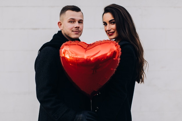 Gratis foto verliefde paar met rode ballon