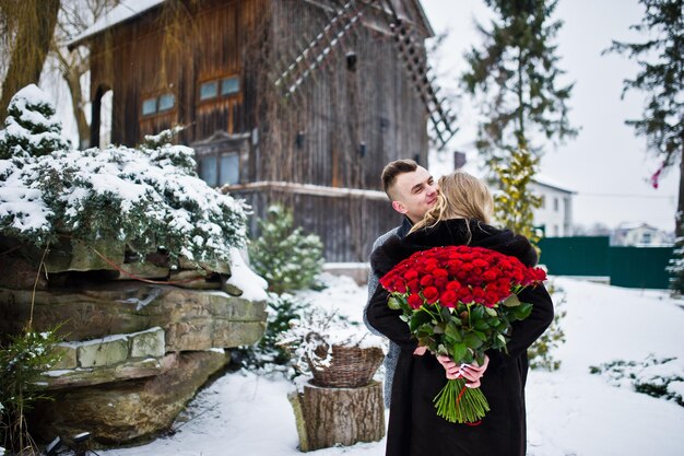 Verliefde paar verliefd op winterdag met groot boeket van 101 rozen