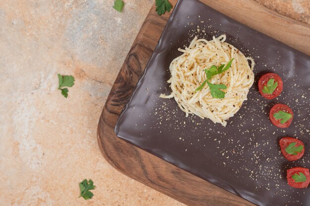 Vermicelli met kruiden en tomaten op zwarte plaat. Hoge kwaliteit illustratie