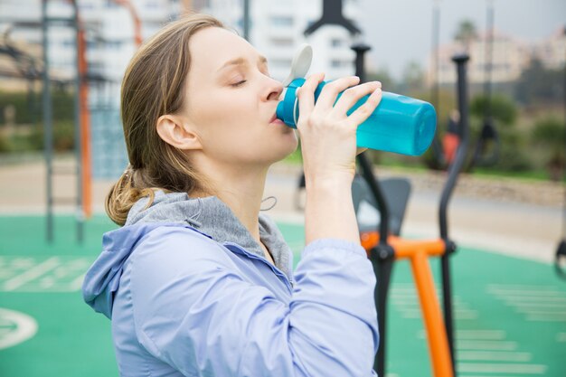 Vermoeide fit meisje dorst tijdens fysieke oefeningen