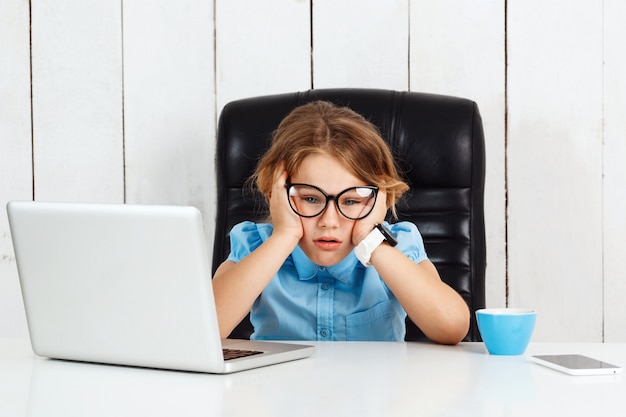 Vermoeide jonge mooie meisjeszitting op werkende plaats in bureau.