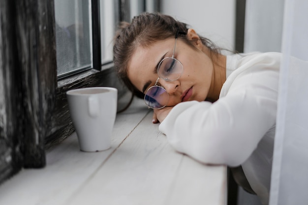 Gratis foto vermoeide onderneemster die haar hoofd op een vensterbank rust