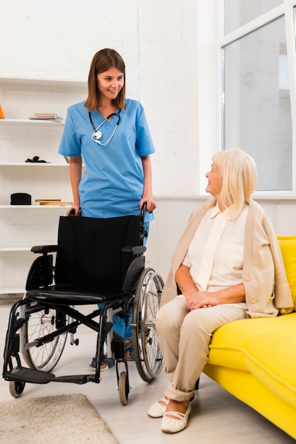Verpleegster die een rolstoel krijgt voor een oude vrouw