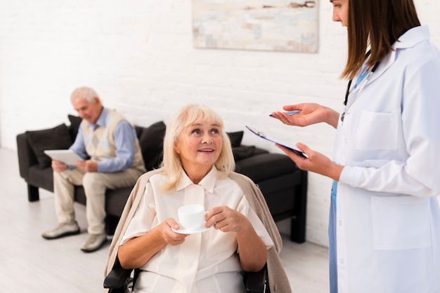 Verpleegster die met oude vrouw spreekt