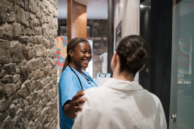 Gratis foto verpleegster die scrubs draagt tijdens het werken in de kliniek