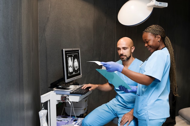 Gratis foto verpleegster die scrubs draagt tijdens het werken in de kliniek