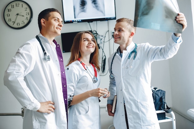 Verpleegster luistert naar de dokter. Studenten in ziekenhuisjassen. Mannen en vrouw staan in een ziekenhuisafdeling.