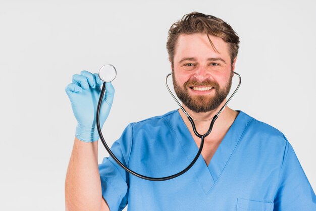 Verpleegstersmens die en stethoscoop glimlacht gebruikt