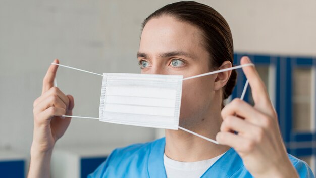 Verpleger die op medisch masker zet