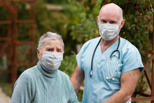 Verpleger poseren met oudere vrouw in verpleeghuis