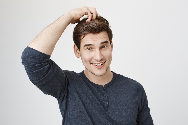Gratis Foto verrast clueless man glimlachend, hoofd krabben