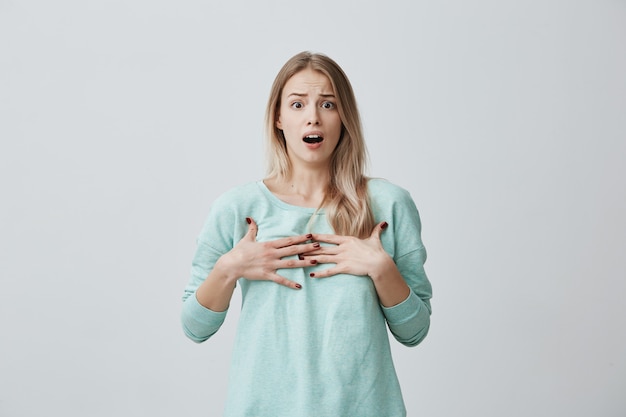 Verrast doodsbange blonde vrouwelijke gebaren met onzekerheid