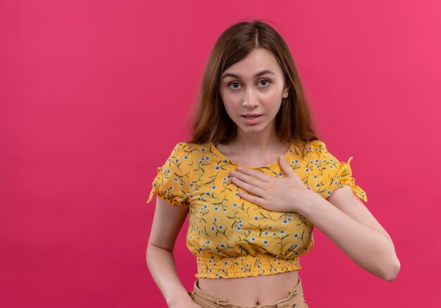 Verrast jong meisje hand op de borst zetten op geïsoleerde roze muur met kopie ruimte