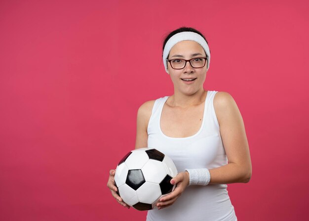 Verrast jong sportief meisje in optische glazen hoofdband dragen