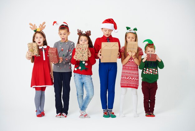 Verrast kinderen kijken naar hun kerstcadeautje