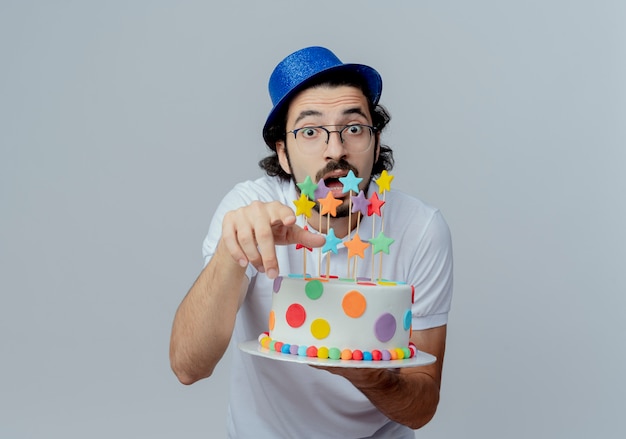 Gratis foto verrast knappe man met bril en blauwe hoed met cake en toont je gebaar geïsoleerd op wit