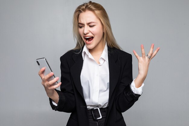 Verrast mooie zakenvrouw chatten via de telefoon staande geïsoleerd.