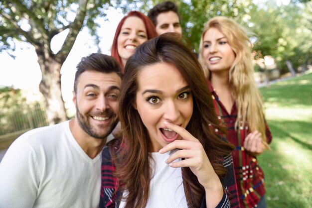 Verraste vrouw met open mond doet een selfie met haar vrienden