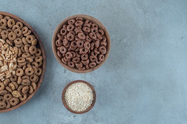 Verrukkelijke cornflakes in de houten kommen, op de blauwe achtergrond. Hoge kwaliteit foto