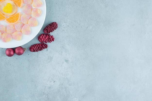 Verrukkelijke schotel van diverse marmelades, met dennenappels en kerstballen op marmer.