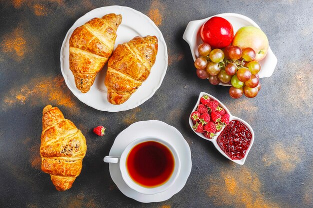 Vers gebakken croissants met frambozenjam en frambozenfruit.