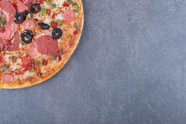 Vers gebakken pepperonispizza op grijze achtergrond.