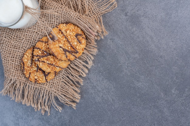 Vers gebakken sesamzaadkoekjes en melk op jute.