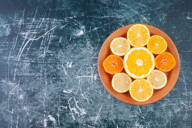 Gratis foto vers gehakte citrusvruchten die in een ronde plaat van klei worden geplaatst.