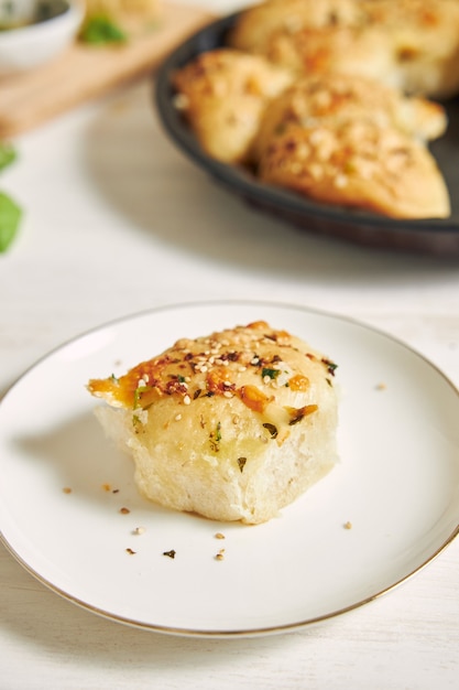 Vers gemaakt heerlijk kaasbubbelpizzabrood met ingrediënten en kaas op een witte tafel