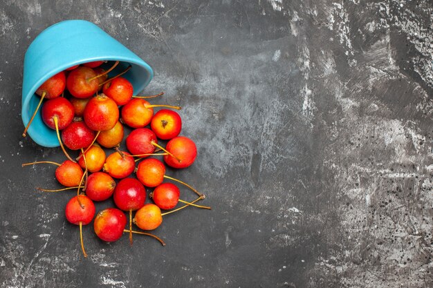 Vers rood kersenfruit in een kom op grijze achtergrond