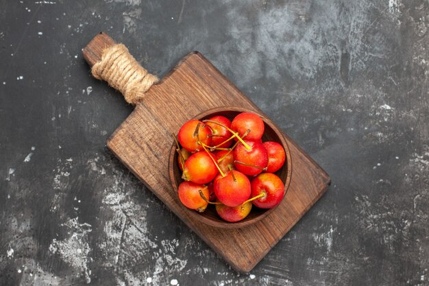 Vers rood kersenfruit in een kom op grijze achtergrond