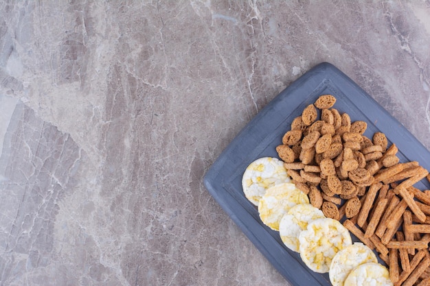 Verscheidenheid aan knapperige crackers op donkere plaat. Hoge kwaliteit foto