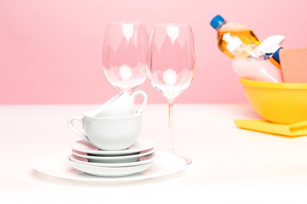 Verschillende borden, keukensponzen en plastic flessen met natuurlijke afwasmiddel voor handwas.