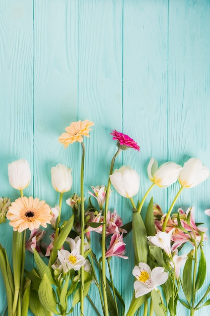 Verschillende heldere bloemen verspreid op tafel