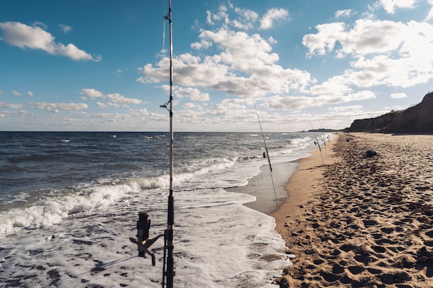 Verschillende hengels op een rij op het strand