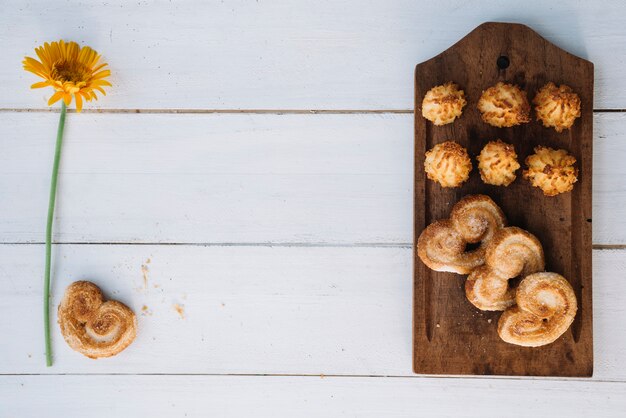 Verschillende koekjes op houten bord met bloem