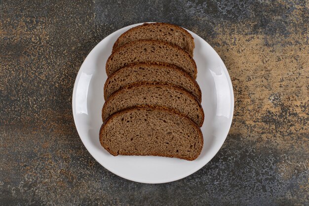 Verschillende sneetjes roggebrood op een witte plaat