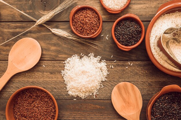 Verschillende soorten biologische rijstkorrels op een houten tafel