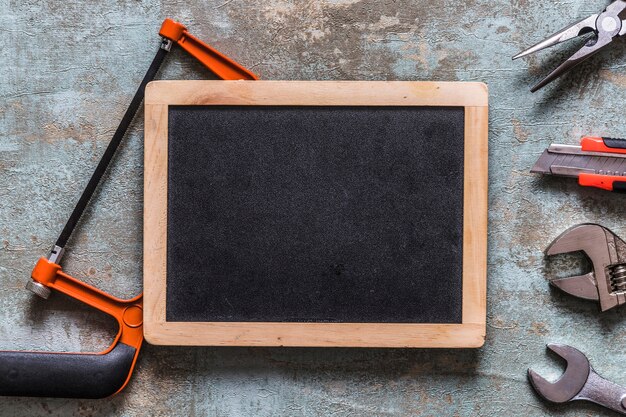 Verschillende werkgereedschappen en schone lei op oude houten bureau