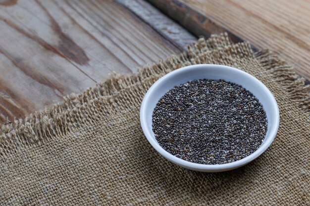 Verschillende zaden - sesam, lijnzaad, lijnzaad, pompoenpitten, papaver, chia in kommen op een rustieke. Kopiëren.