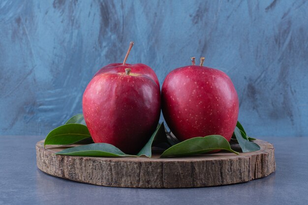 Verse appels en bladeren op het bord op het donkere oppervlak