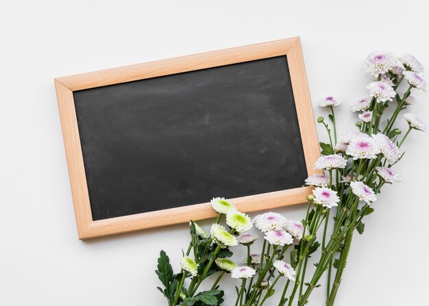 Verse bloemen op stengels met schoolbord