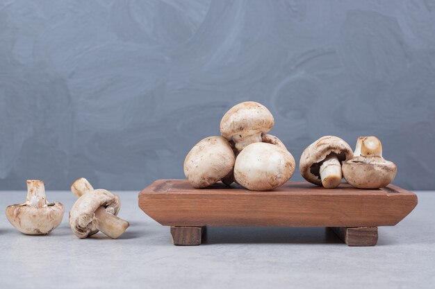 Verse champignons op houten plaat.