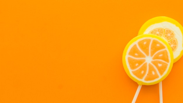 Verse citrusvruchtenlollys op oranje achtergrond