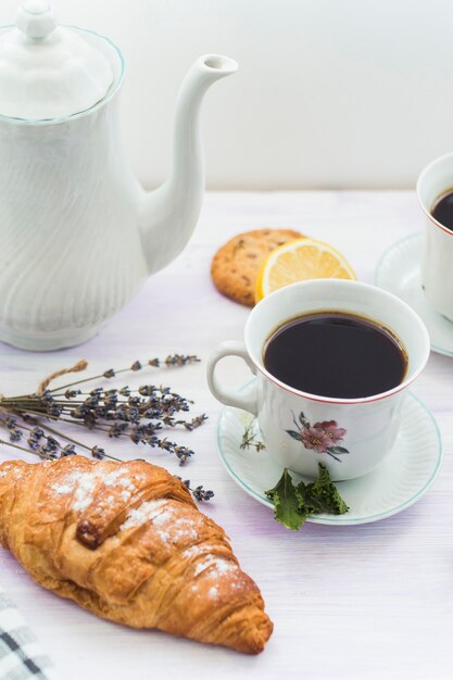 Verse croissant met kopje thee bij het ontbijt