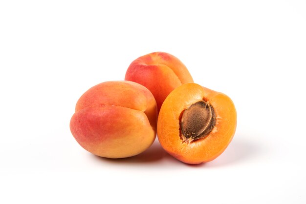 Verse gele abrikozen die op wit worden geïsoleerd